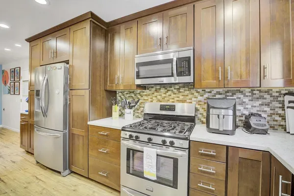 a kitchen with stainless steel appliances a table and chairs in it