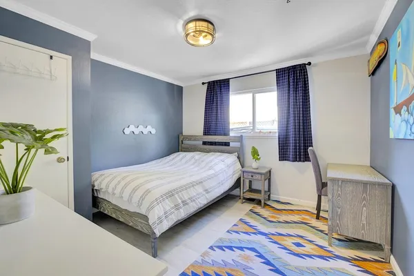 a bedroom with a bed and painting on the wall