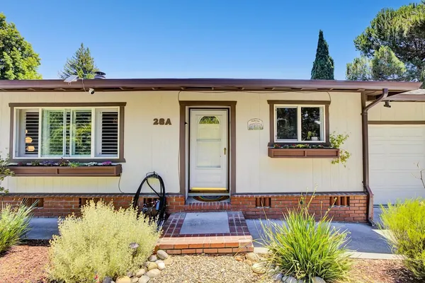 a dining hall with stainless steel appliances kitchen island granite countertop a dining table chairs and a refrigerator