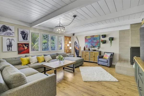 a kitchen with stainless steel appliances granite countertop a dining table chairs refrigerator and microwave