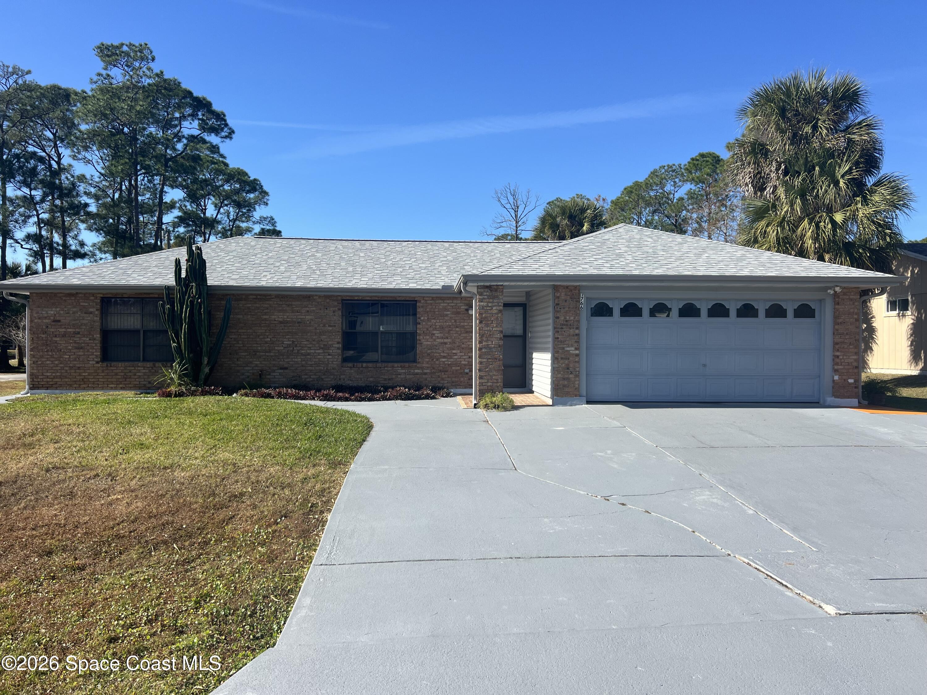1766 Sand Road Southeast Palm Bay, FL 32909 - Photo 1 of 13 a front view of a house with a yard