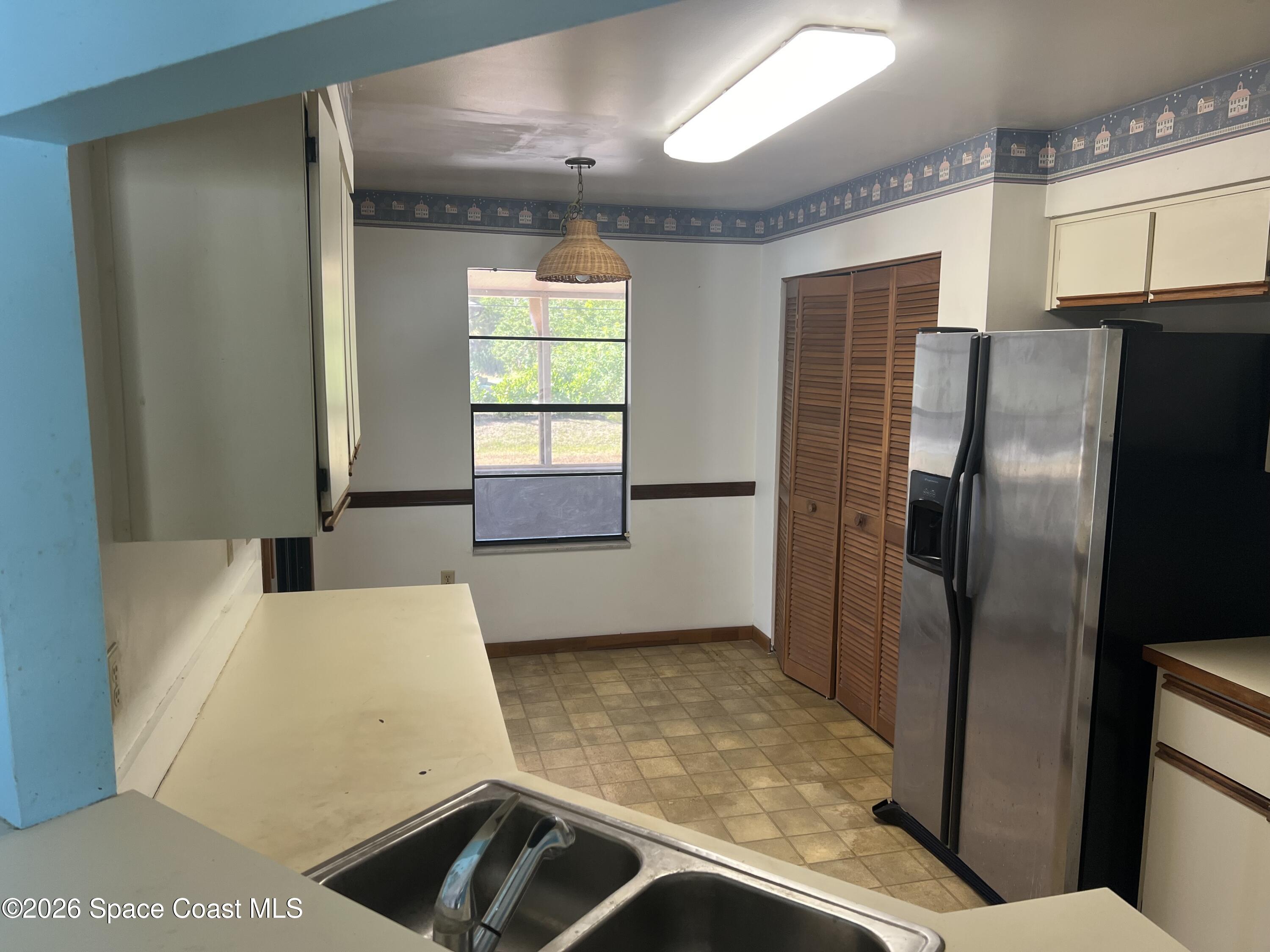 1766 Sand Road Southeast Palm Bay, FL 32909 - Photo 7 of 13 a kitchen with stainless steel appliances a refrigerator and a stove