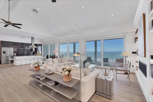 a kitchen with stainless steel appliances a dining table chairs refrigerator and sink