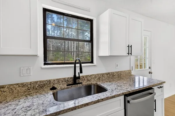 a kitchen with granite countertop a sink and a window