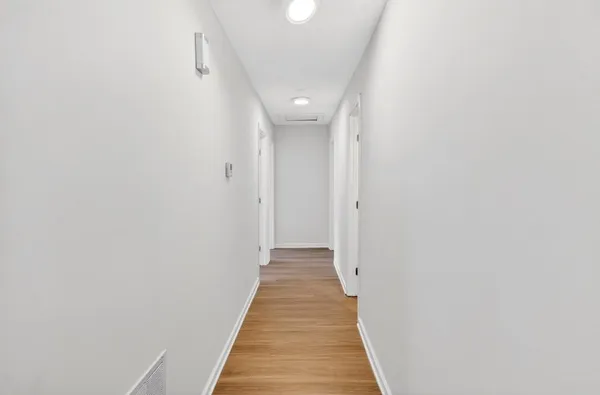 a view of a hallway with wooden floor