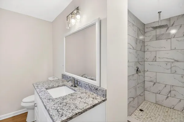 a bathroom with a granite countertop sink and a mirror