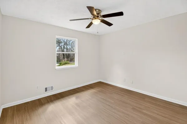 a view of a big room with wooden floor and windows