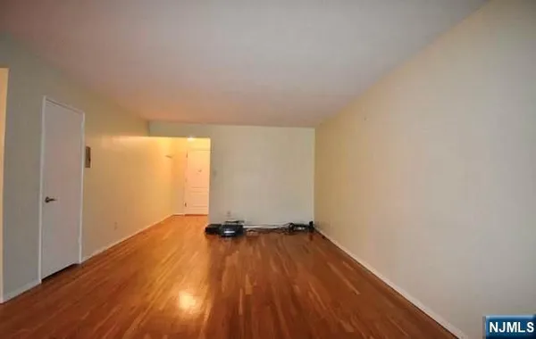 a view of a room with wooden floor a ceiling fan and window