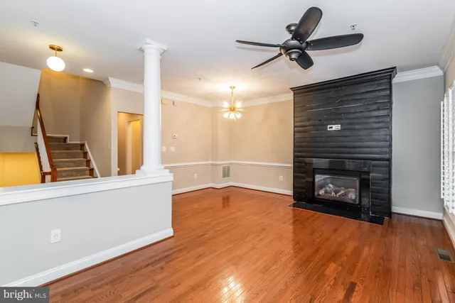 a view of an empty room with a fireplace and wooden floor