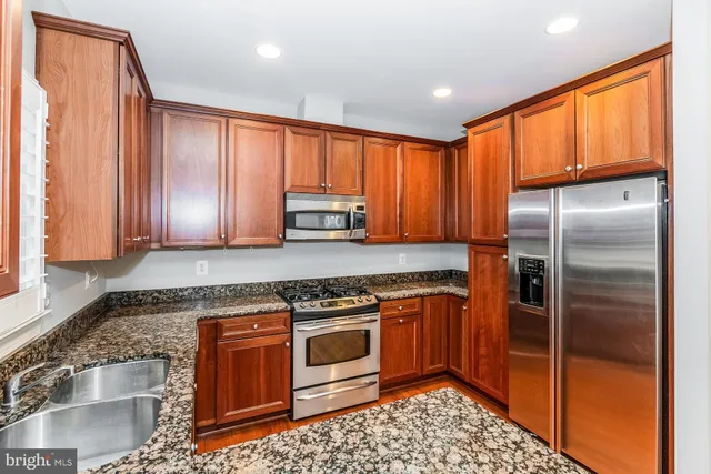 a kitchen with stainless steel appliances granite countertop a stove a refrigerator and cabinets