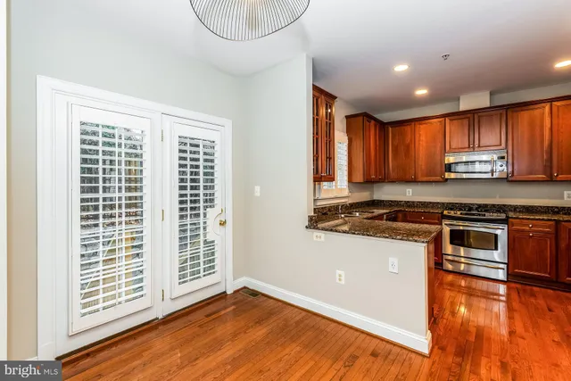 a view of kitchen with wooden floor and electronic appliances