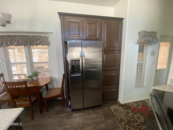 a living room with stainless steel appliances granite countertop furniture a refrigerator and a window