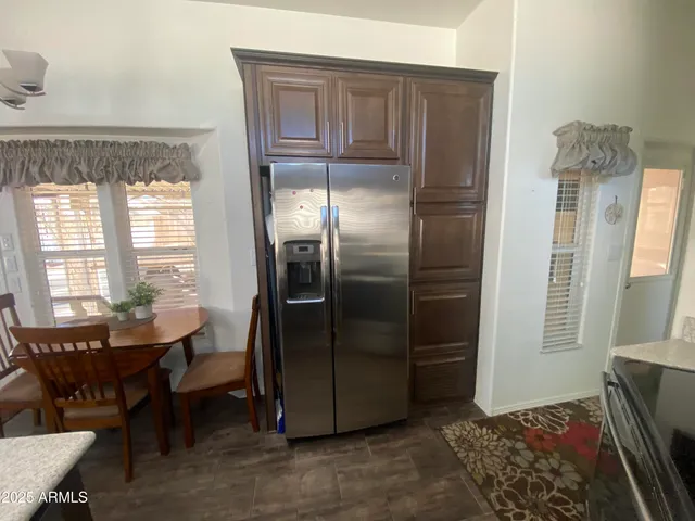 a living room with stainless steel appliances granite countertop furniture a refrigerator and a window