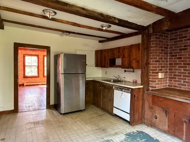 a kitchen with stainless steel appliances granite countertop a refrigerator a stove and a sink