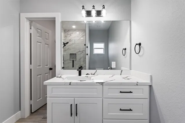 a bathroom with a sink vanity and mirror