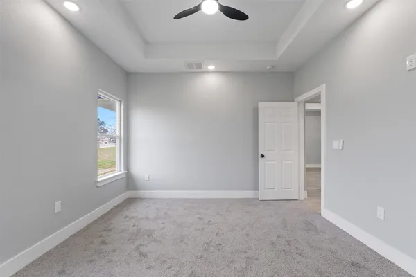 a view of an empty room and a ceiling fan window