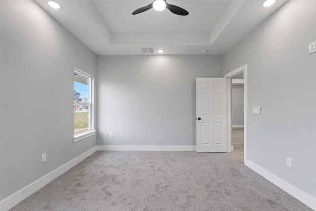 a view of an empty room and a ceiling fan window