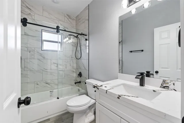 a bathroom with a sink mirror bathtub and toilet