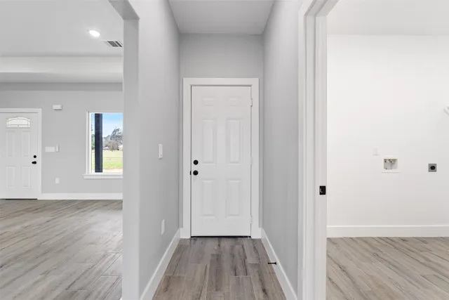 a view of a hallway with wooden floor