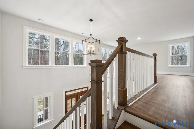 a view of an entryway wooden floor and chandelier