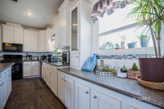 1577 North Calvert Boulevard Ridgecrest, CA 93555 - Photo 18 of 35 a kitchen with granite countertop a sink stainless steel appliances and cabinets