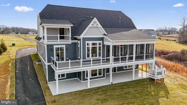a view of a white house with large windows next to a road