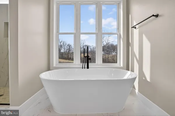 a kitchen with stainless steel appliances kitchen island granite countertop a refrigerator a sink and white cabinets