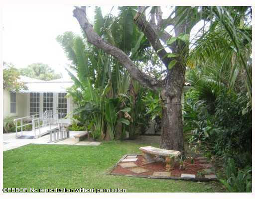 312 Sunset Road West Palm Beach, FL 33401 - Photo 1 of 8 a view of backyard with table and chairs and a large tree