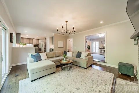 a living room with furniture and a chandelier