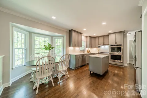 a kitchen with a table chairs refrigerator and microwave