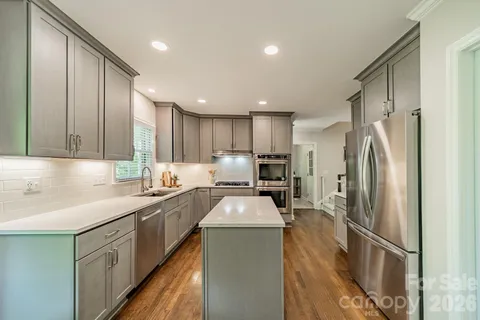 a kitchen with stainless steel appliances granite countertop a sink stove and refrigerator