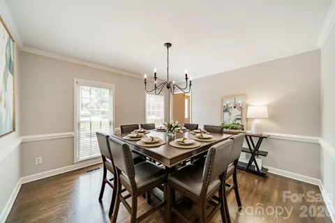 a dining room with furniture a chandelier and wooden floor