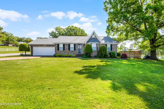 a view of a house with a big yard and palm trees
