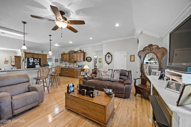 a living room with furniture kitchen view and a chandelier