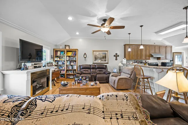 a living room with furniture kitchen view and a flat screen tv