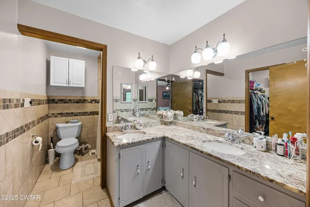 a bathroom with a granite countertop sink a toilet and mirror