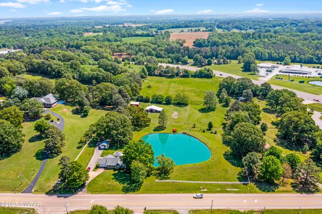 an aerial view of a residential houses with outdoor space and city view