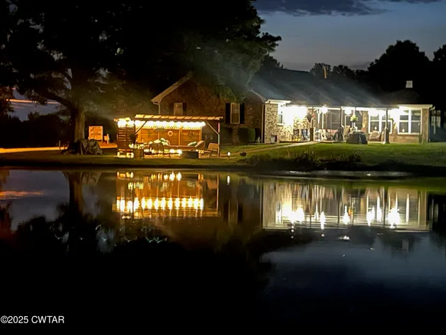 a view of a house with a yard and large trees