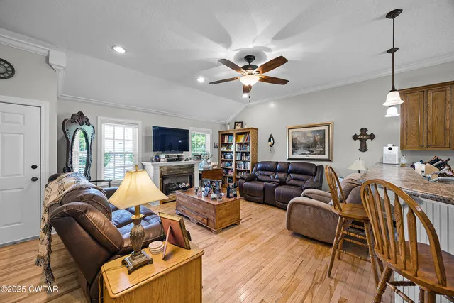 a living room with furniture a flat screen tv and kitchen view