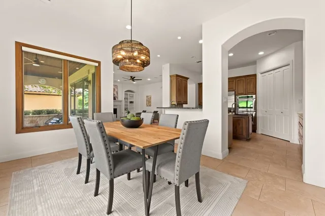 a view of a dining room and livingroom with furniture wooden floor a rug a potted plant and a chandelier