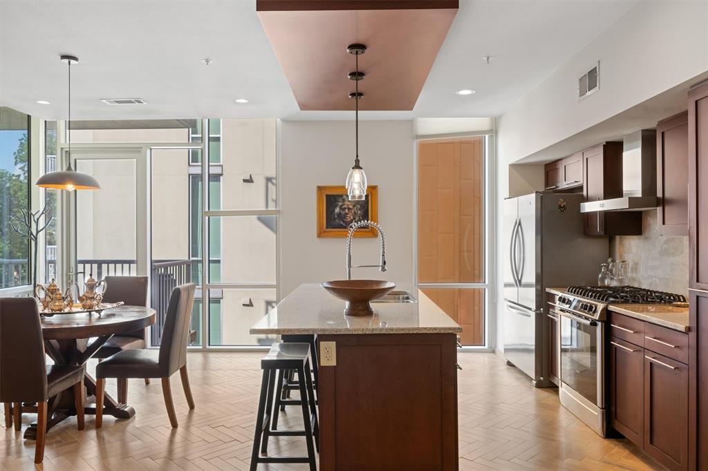 1600 Barton Springs Road, Unit 5301 Austin, TX 78704 - Photo 2 of 19 Kitchen with light stone countertops, gas stove, a center island with sink, parquet flooring, and floor to ceiling windows