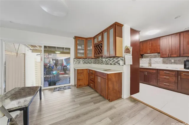 a large kitchen with stainless steel appliances granite countertop a stove a sink dishwasher and a refrigerator with wooden cabinets