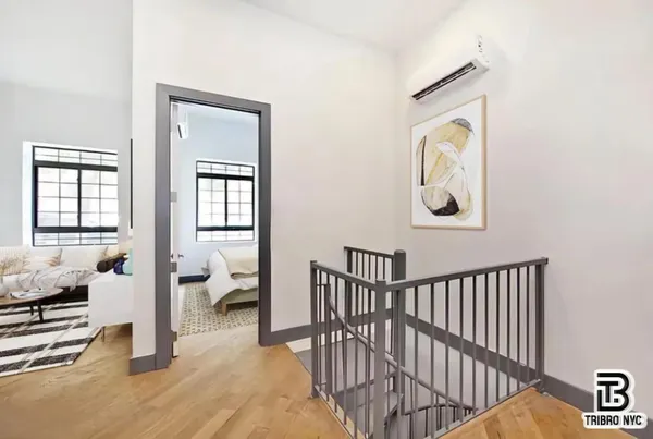 a view of a hallway with bedroom and wooden floor