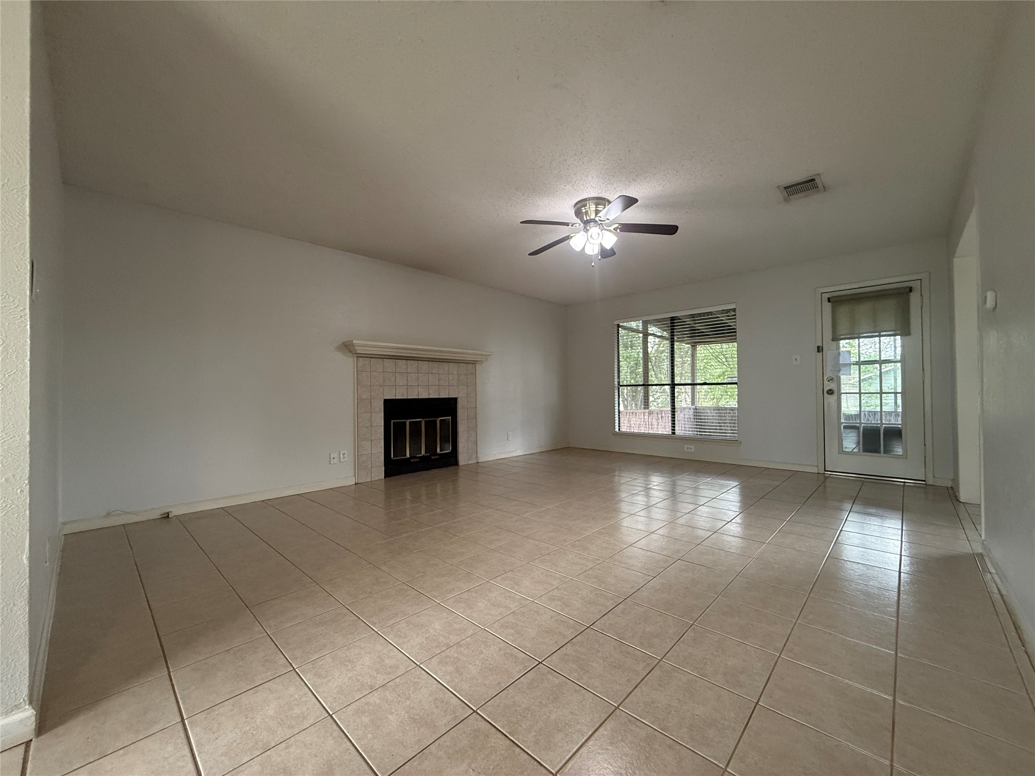7900 Turquoise Trail Austin, TX 78749 - Photo 3 of 21 A comfortable living area features a tile-surrounded fireplace and an outdoor view.