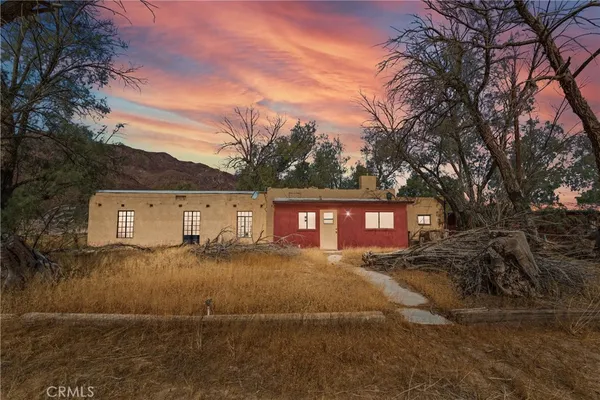 a view of a yard in front of a house with large trees
