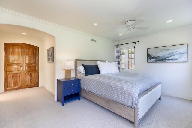 a bedroom with a large bed and a chandelier