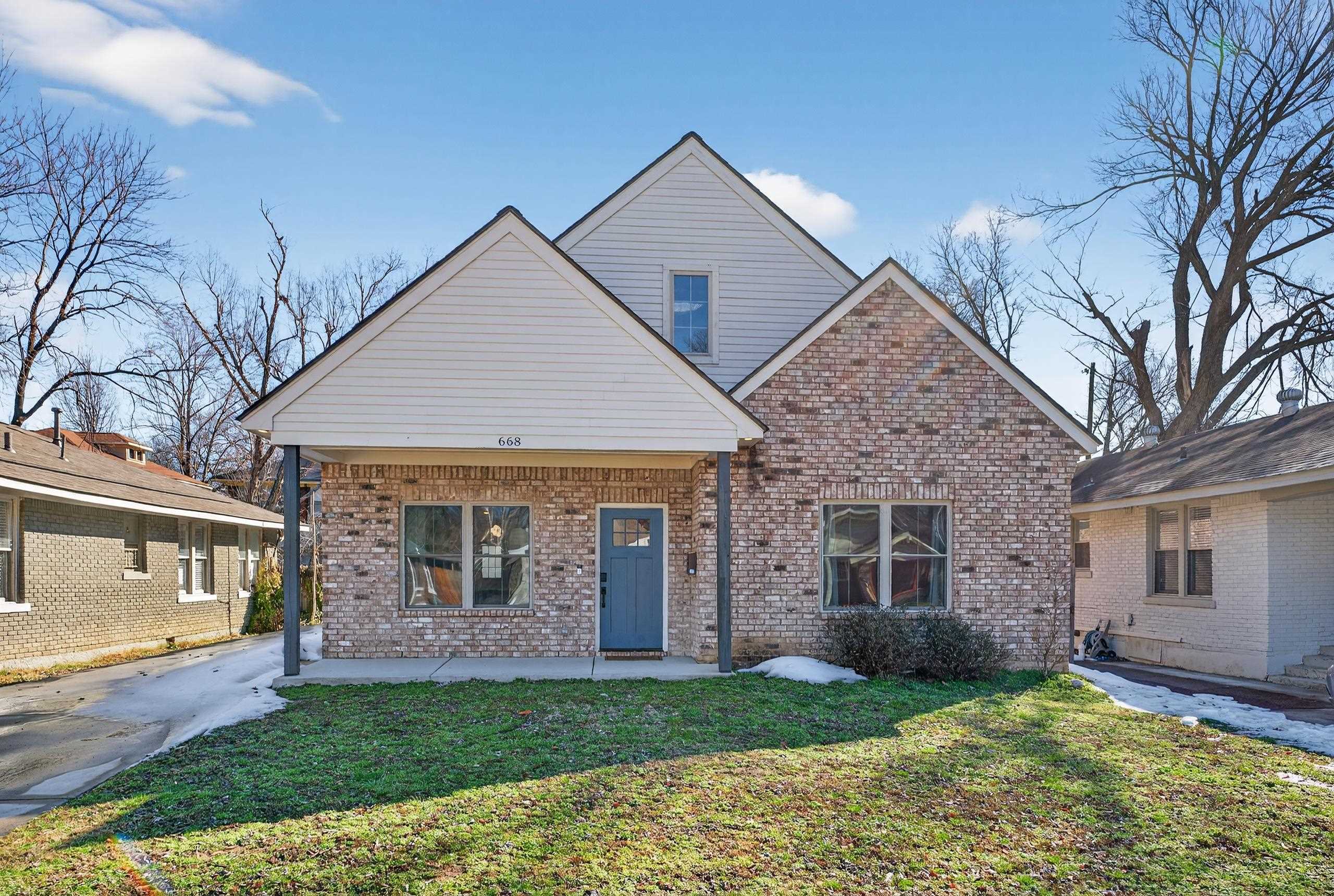View of front of home featuring brick siding, a front yard, and a porch