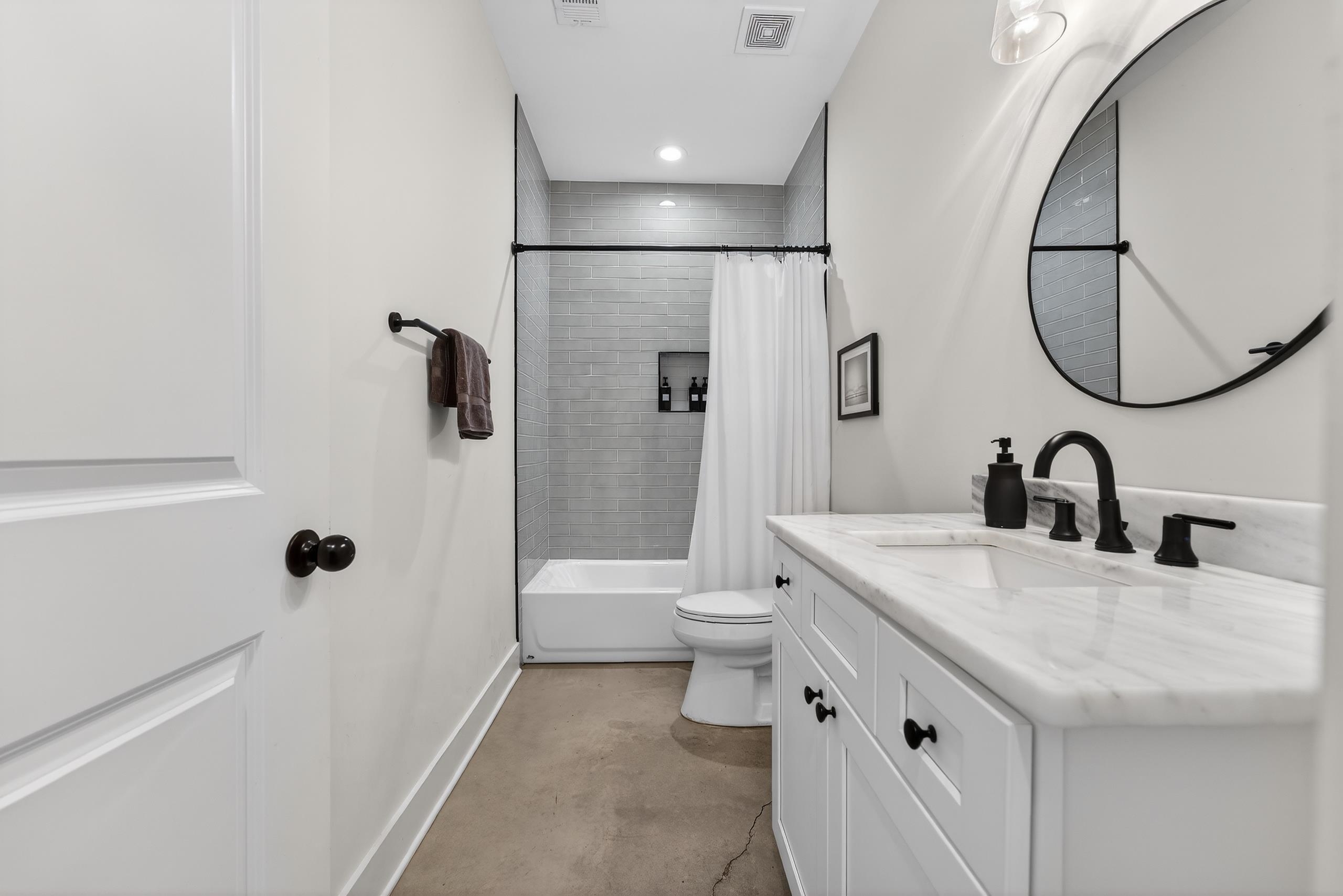 668 Hawthorne Street Memphis, TN 38107 - Photo 18 of 24 Bathroom with concrete floors, vanity, shower / bathtub combination with curtain, and recessed lighting