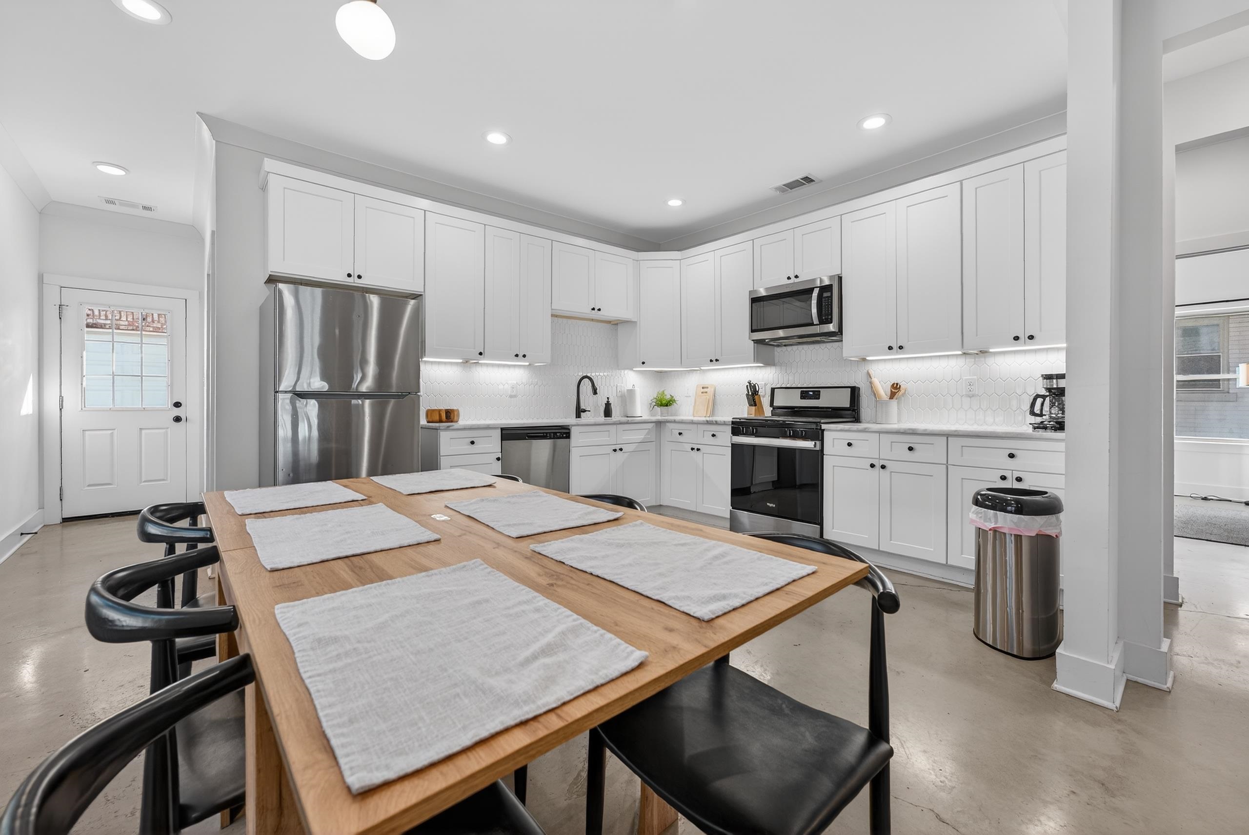 668 Hawthorne Street Memphis, TN 38107 - Photo 10 of 24 Kitchen featuring healthy amount of natural light, white cabinets, stainless steel appliances, concrete flooring, and recessed lighting