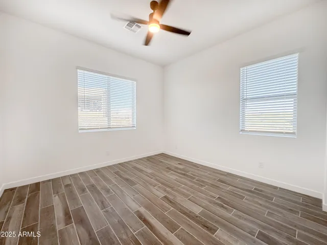 a view of a hallway with wooden floor and closet area